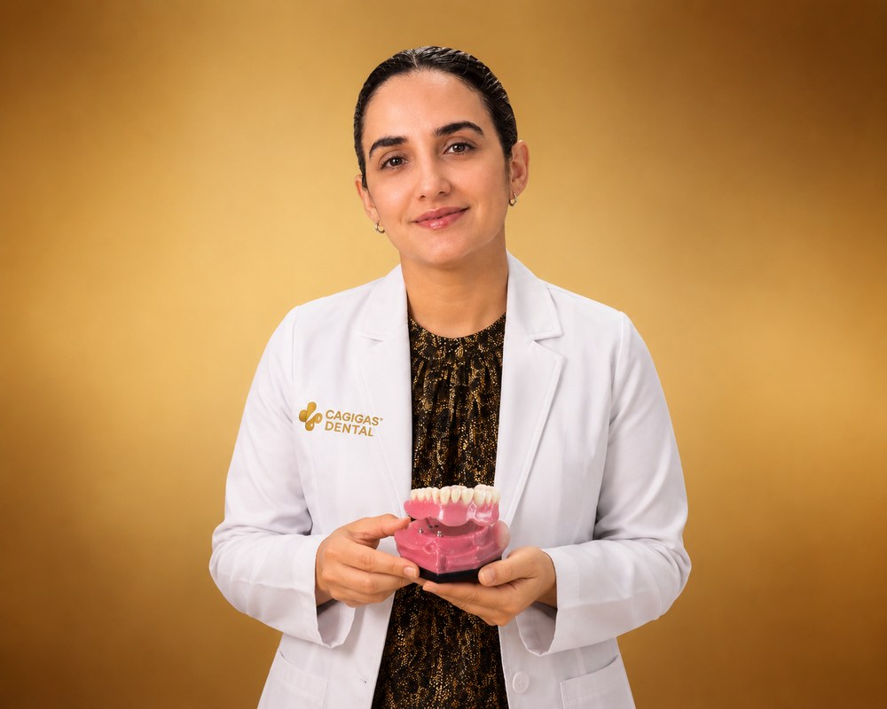 Dr. Arianna Romero holding an overdenture model at Cagigas Dental in West Palm Beach