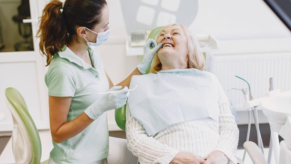 Smiling senior woman with her dentist after an overdentures evaluation in West Palm Beach