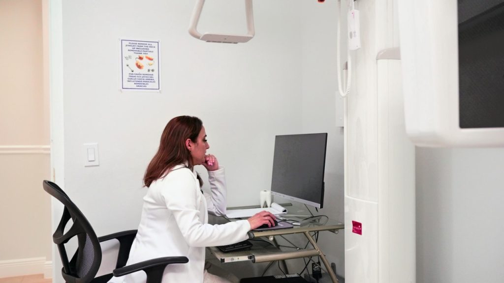 Dentist reviewing digital X-rays at a computer at Cagigas Dental in Lake Worth